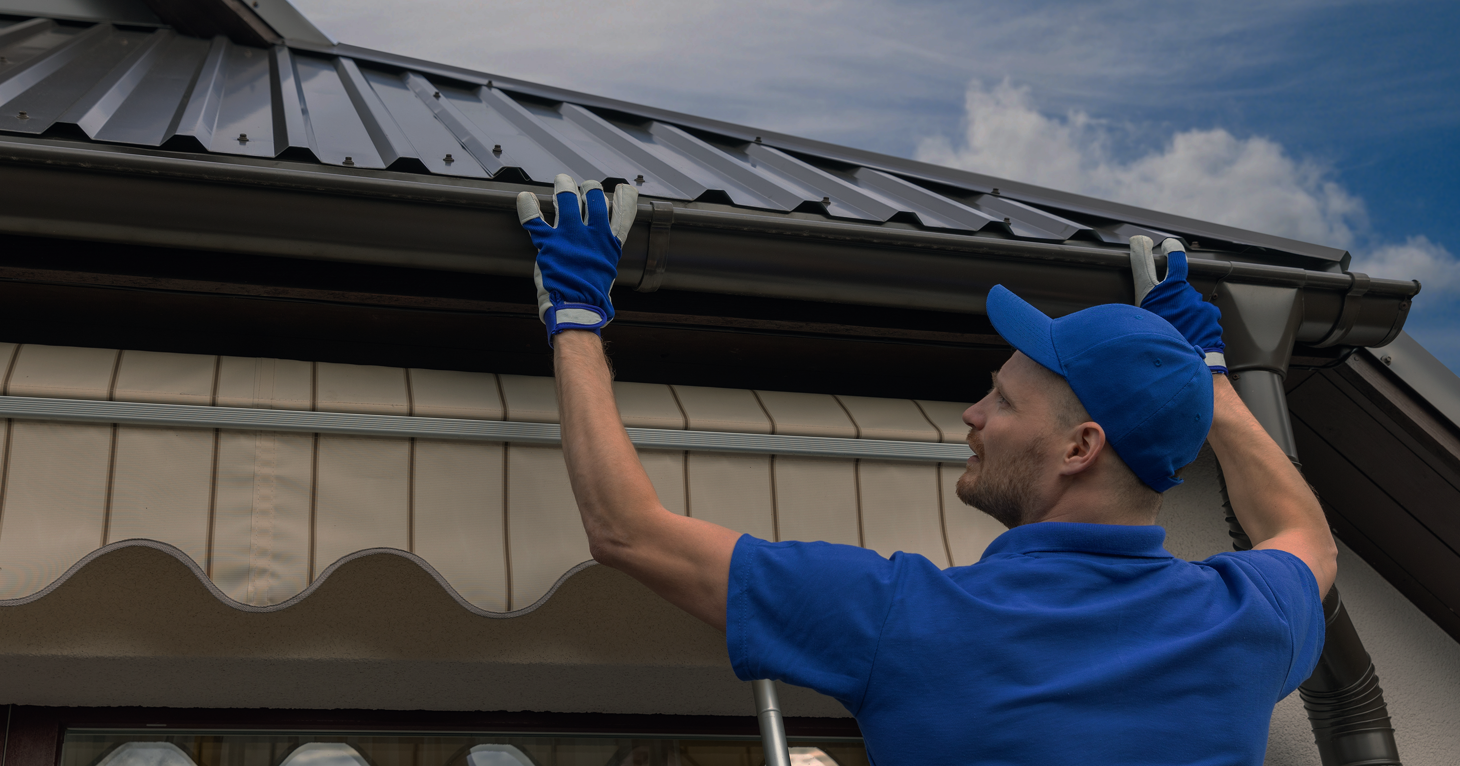 man-installing-gutters-long-lg gutter cleaning by roofing formula