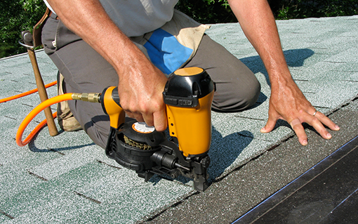 man-using-nail-gun Roof repair roofing services in seattle